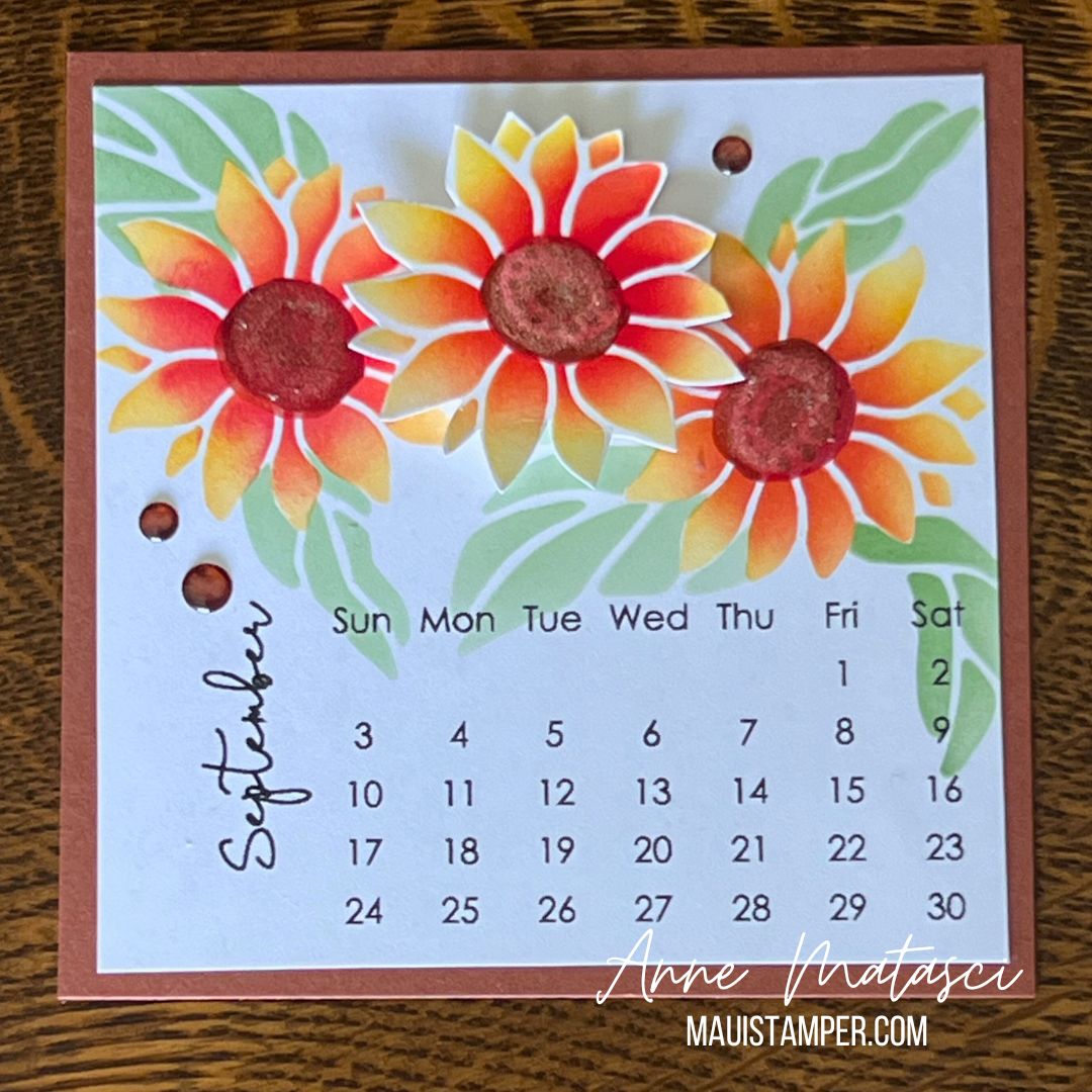 A Handmade calendar page for September. It features 3 stenciled flowers in yellows and reds with green leaves.
