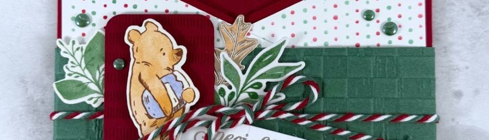 An open envelope with Winnie the Pooh and Christmas Greenery