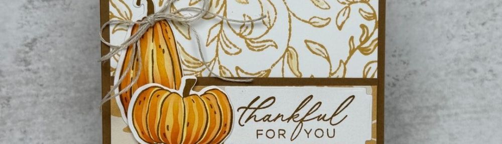 A card with a golden leafy background and two pumpkins
